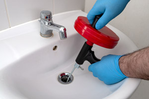 Person cleaning drain. All Pro Plumbing provides exceptional commercial drain cleaning services in Portland OR & Vancouver WA.